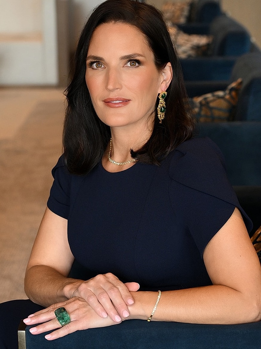 Woman in black outfit smiling indoors.