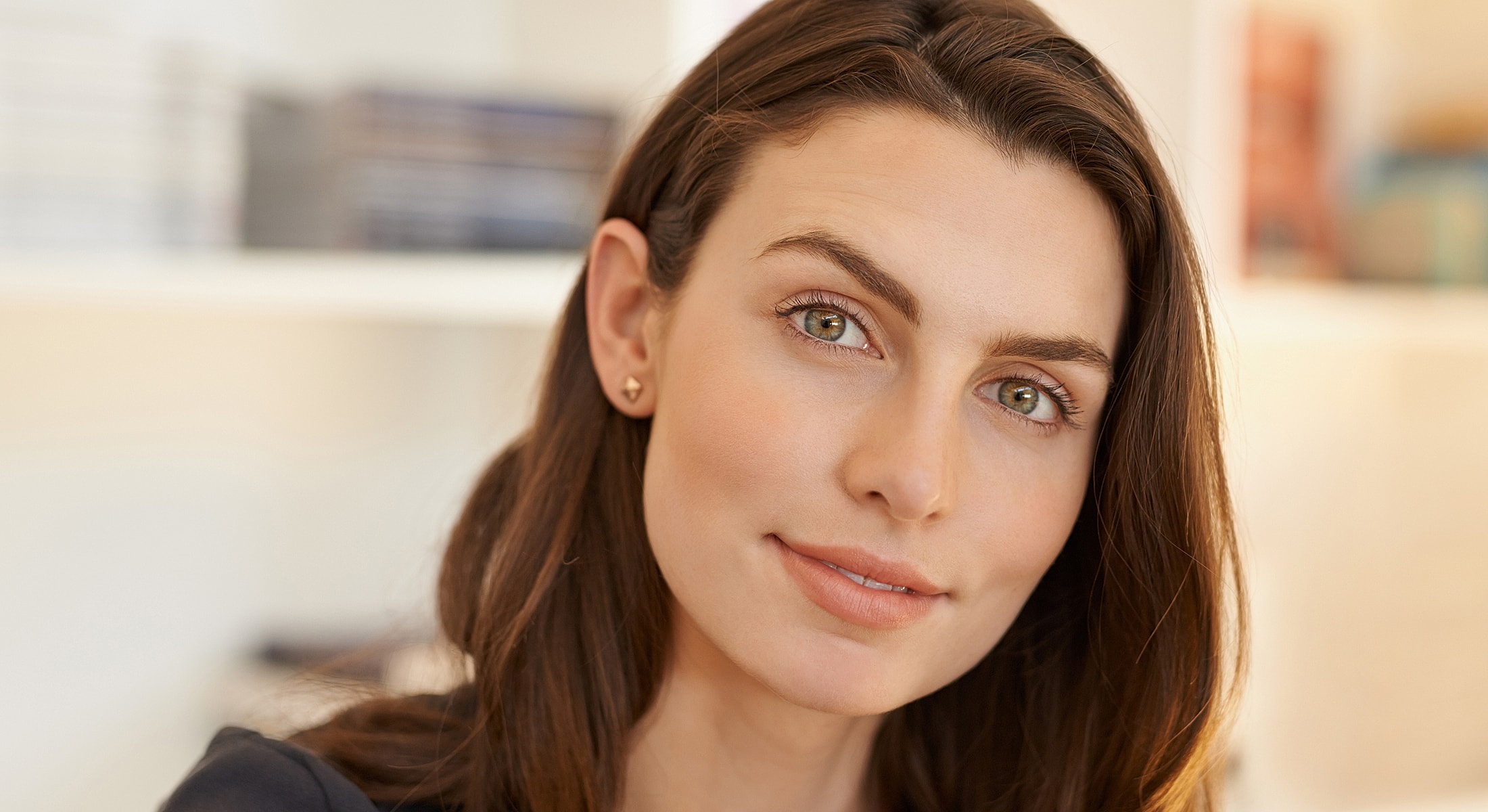 Smiling woman with long hair and green eyes.