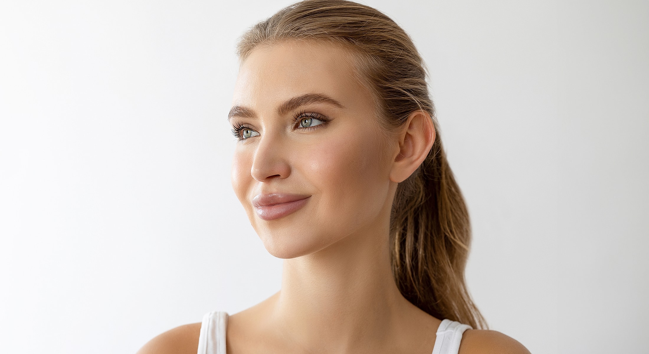 Smiling woman with long hair against a white background.